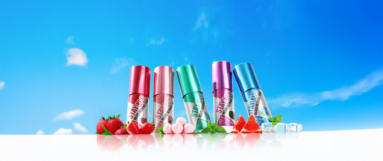Breath Freshener Spray Bottles with fruits and bubble gum against a blue sky background