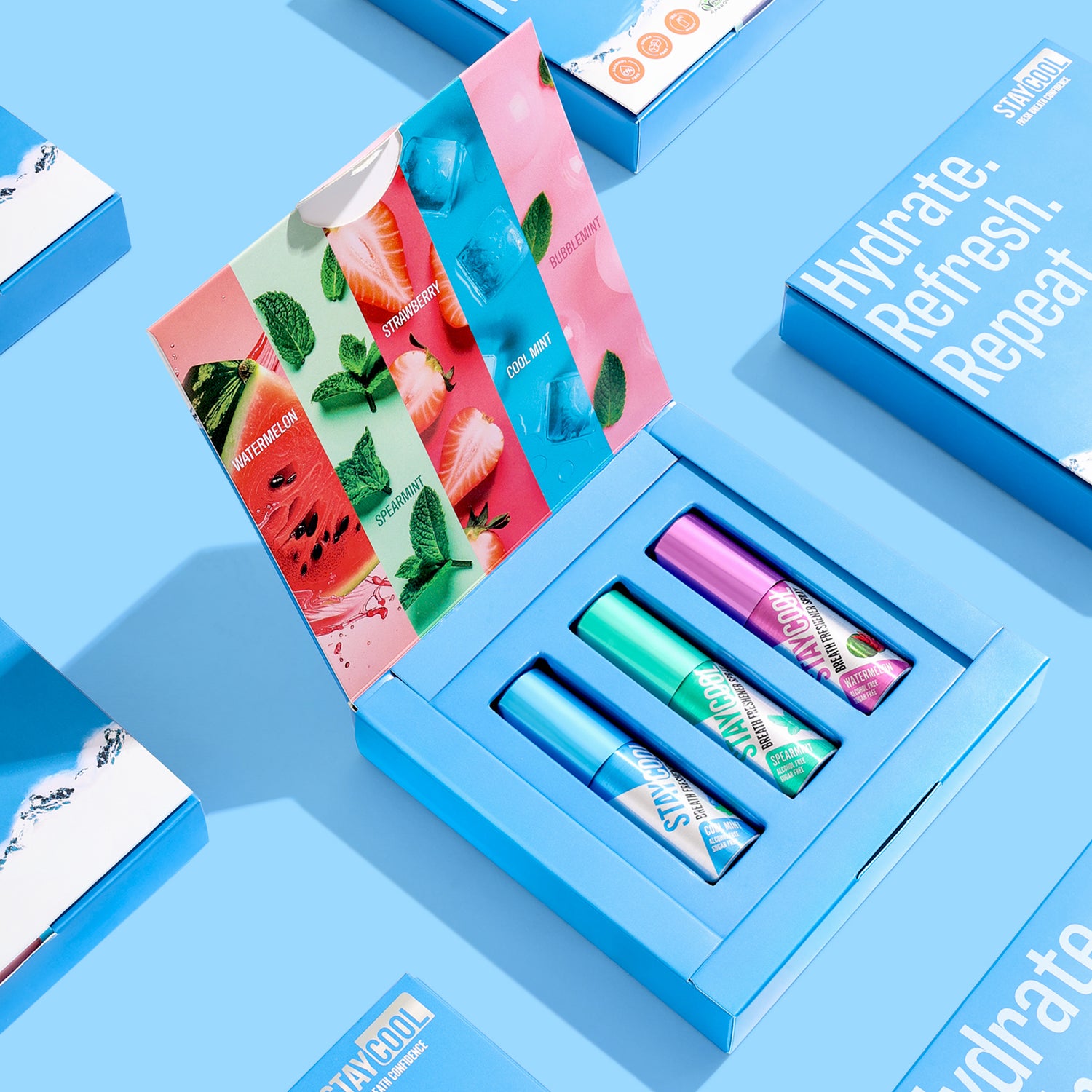 Stay Cool breath freshener spray set featuring vibrant inner packaging, surrounded by matching packaging designs on a clean blue background