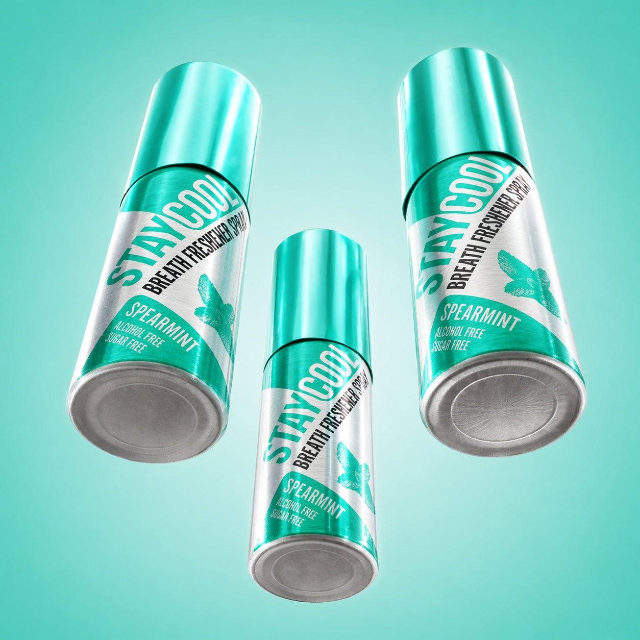 Three cans of Stay Cool breath freshening spearmint flavor sprays on a light blue background